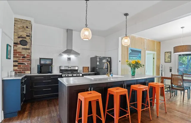 a kitchen with a dining table chairs cabinets and stainless steel appliances