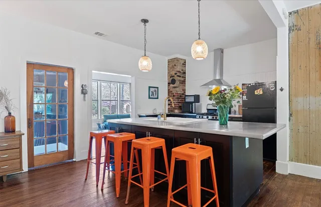 a dining table chairs wooden floor and a chandelier