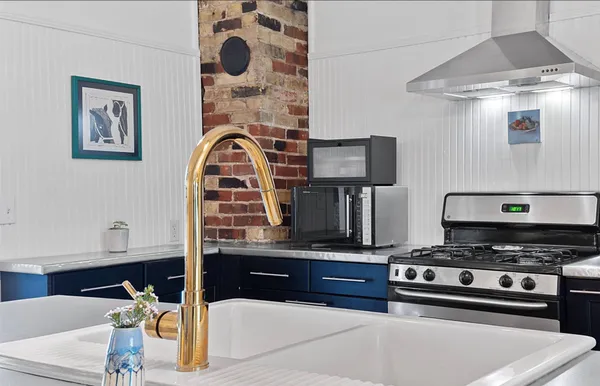 a kitchen with stainless steel appliances kitchen island a stove and a sink