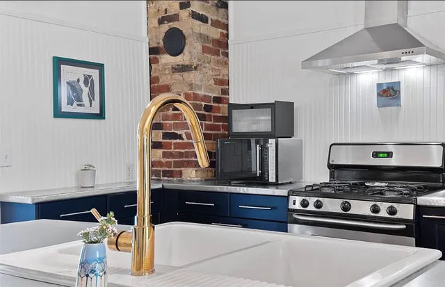 a kitchen with stainless steel appliances kitchen island a stove and a sink