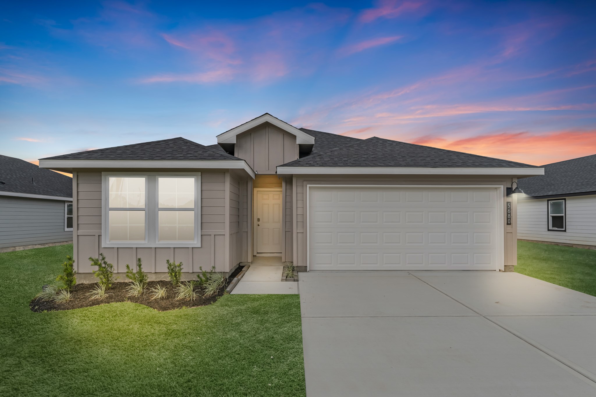 a front view of a house with yard and green space