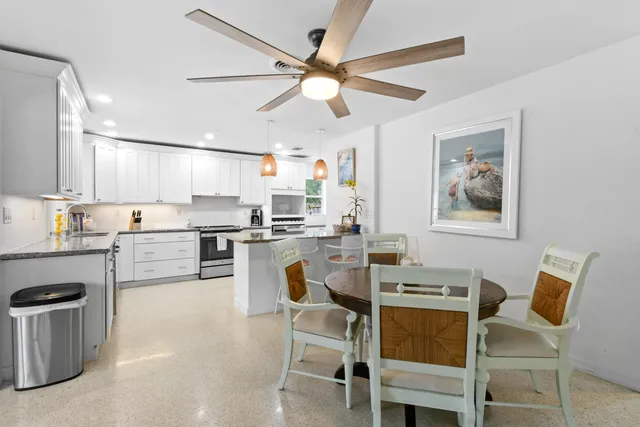 a kitchen with a dining table chairs stainless steel appliances and cabinets