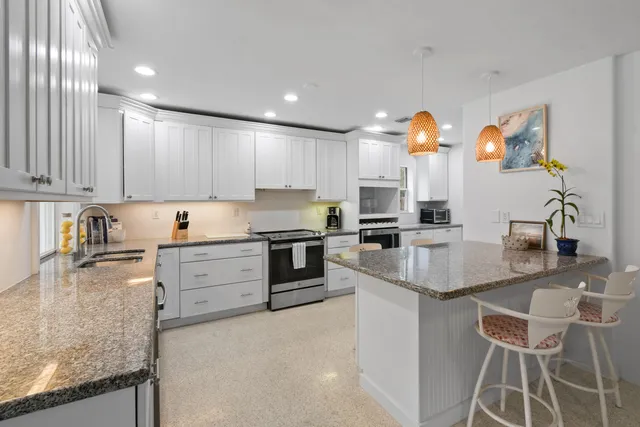 a kitchen with granite countertop white cabinets and white appliances