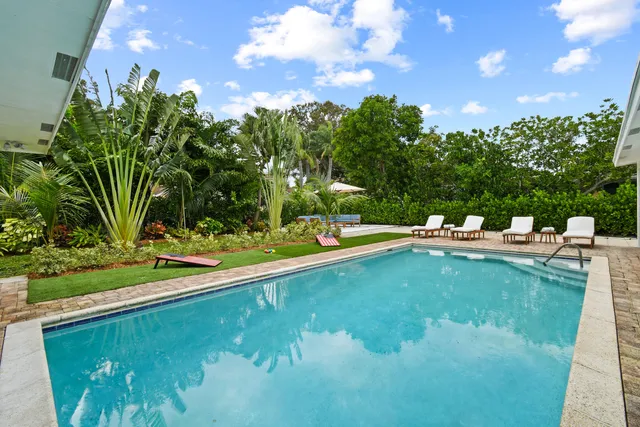 a view of a patio with couches table and chairs and potted plants