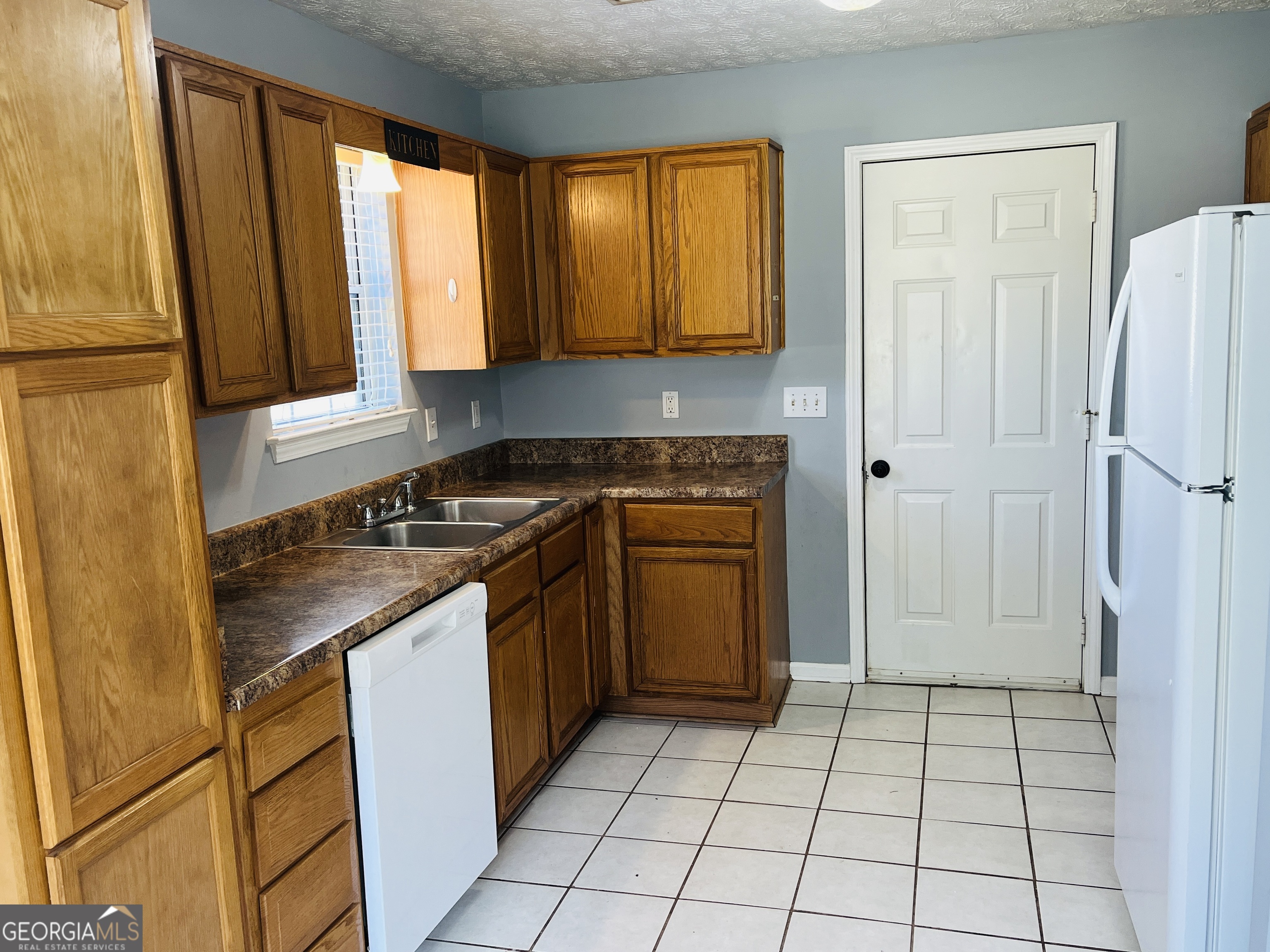 405 Peeks Crossing Drive Senoia, GA 30276 - Photo 7 of 31 a kitchen with a sink a stove and a refrigerator