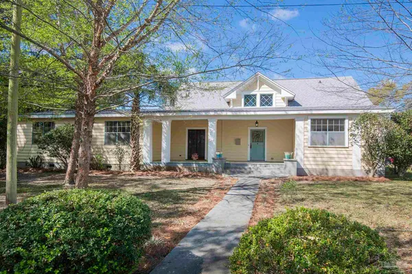 a front view of a house with a garden and yard