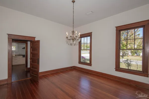 a view of a room with wooden floor and chandelier