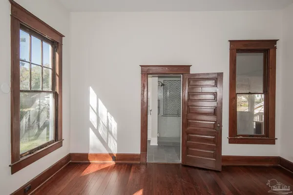 a view of bedroom with wooden floor and window