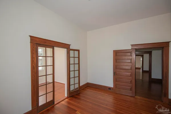 a view of an empty room with wooden floor
