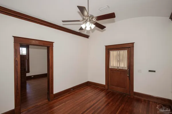 a view of an empty room with wooden floor and a window
