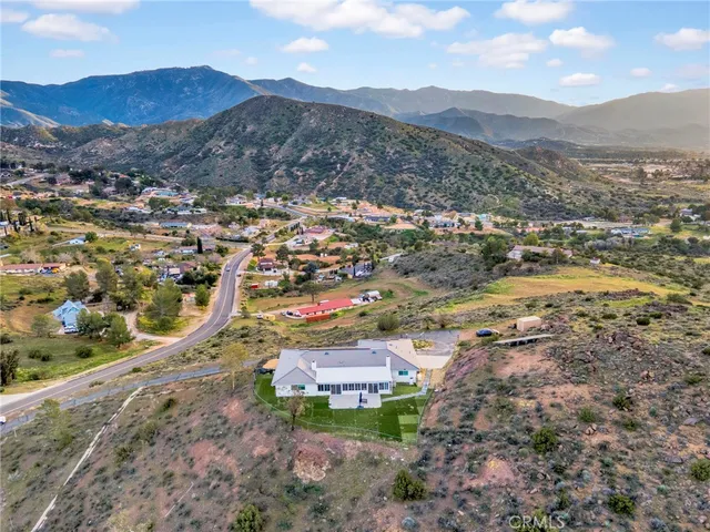 an aerial view of residential houses with outdoor space and trees