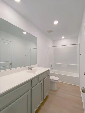 a bathroom with a granite countertop sink a toilet and bathtub