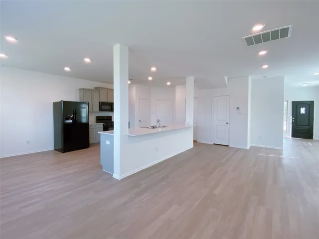 a view of a kitchen with refrigerator and a stove