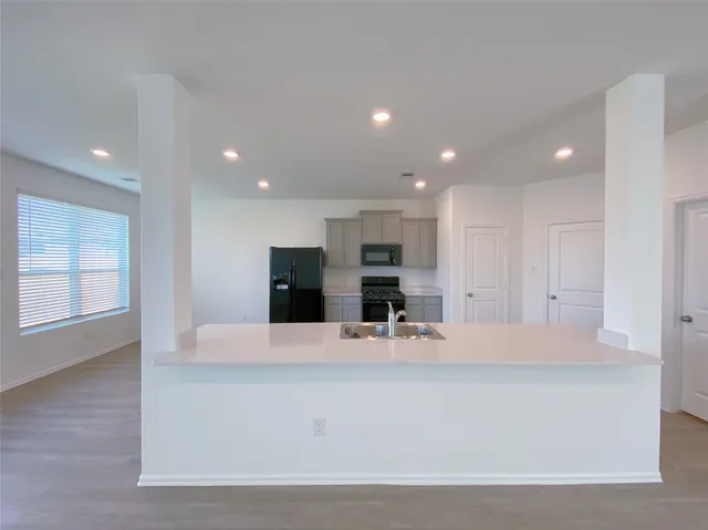 a view of kitchen with stainless steel appliances kitchen island sink and hall