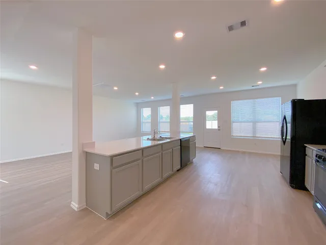 a kitchen with stainless steel appliances a refrigerator and a stove top oven