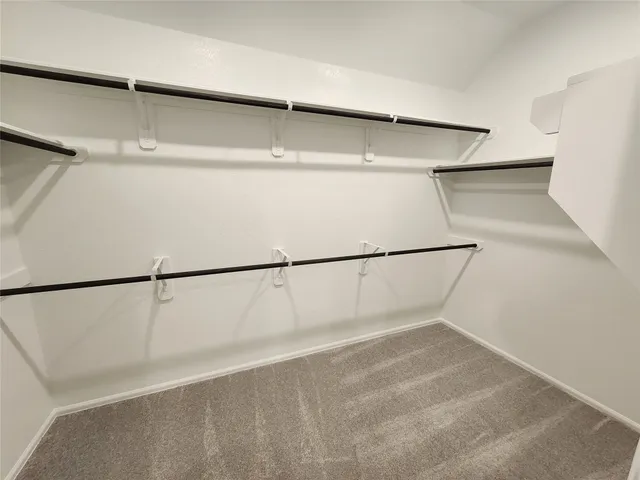 a view of walk in closet with empty racks