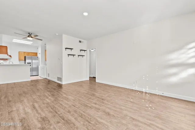 a view of empty room with wooden floor