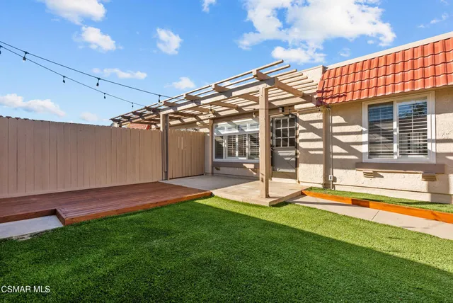 a view of an house with backyard and a patio