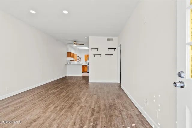 a view of empty room with wooden floor