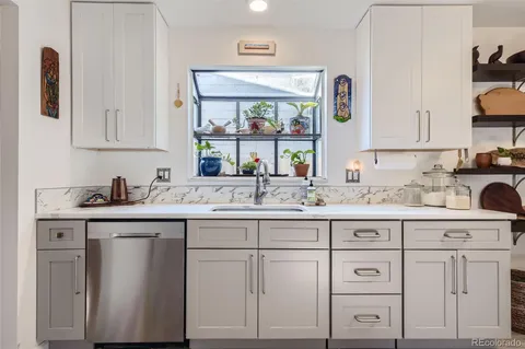 a kitchen with white cabinets and sink