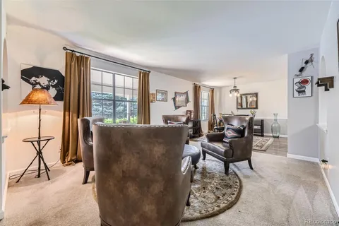 a living room with furniture and floor to ceiling windows