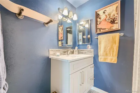 a bathroom with a granite countertop sink a toilet and a mirror
