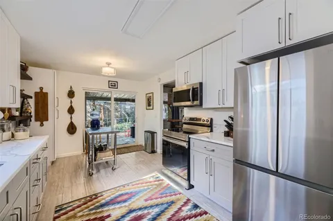 a kitchen with stainless steel appliances a stove a sink cabinets and a refrigerator
