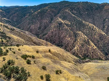 a view of a dry yard with mountains in the background