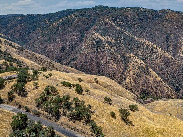 a view of a dry yard with wooden fence