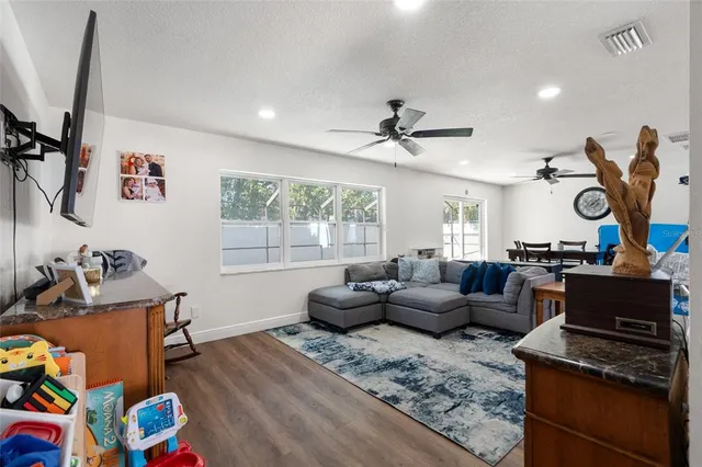 a living room with furniture a flat screen tv and a window