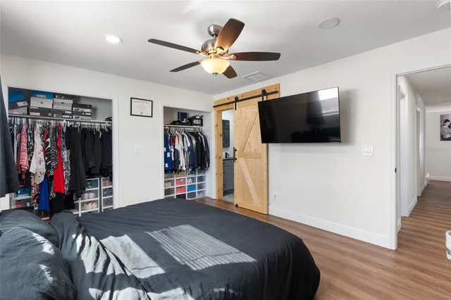 a bed room with a bed a flat screen tv and a walk in closet