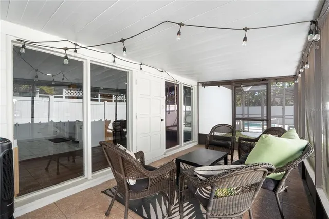 a dining room with furniture a chandelier and glass door