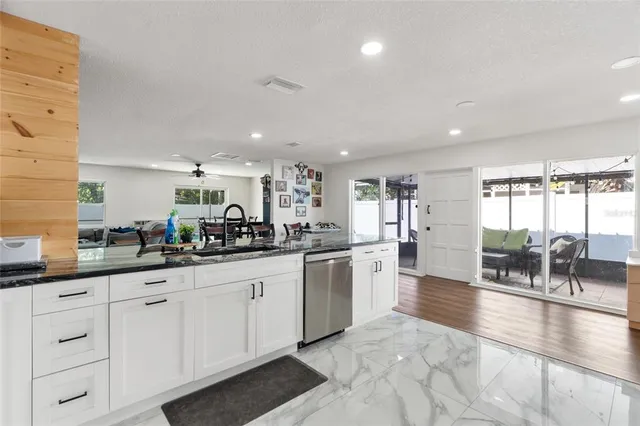 a kitchen with sink and view of living room