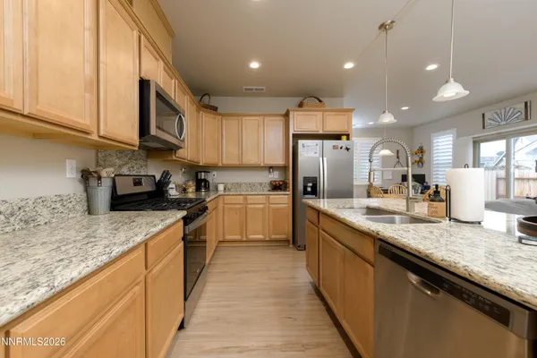 a large kitchen with stainless steel appliances granite countertop a sink and cabinets