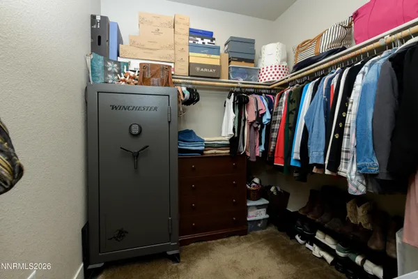 a view of walk in closet with clothes and shoes