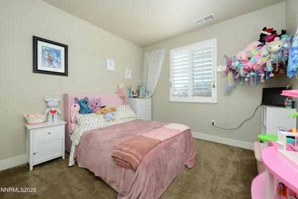a bedroom with a bed potted plant on the dresser and a window