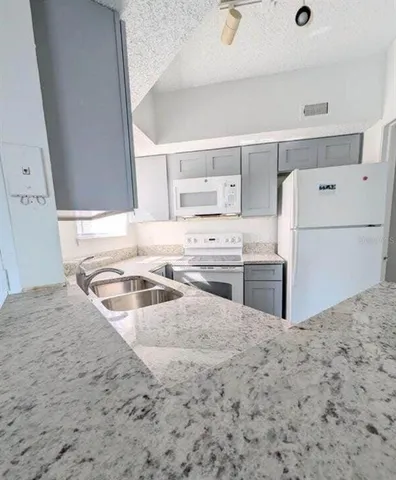 a kitchen with a stove a sink and a refrigerator