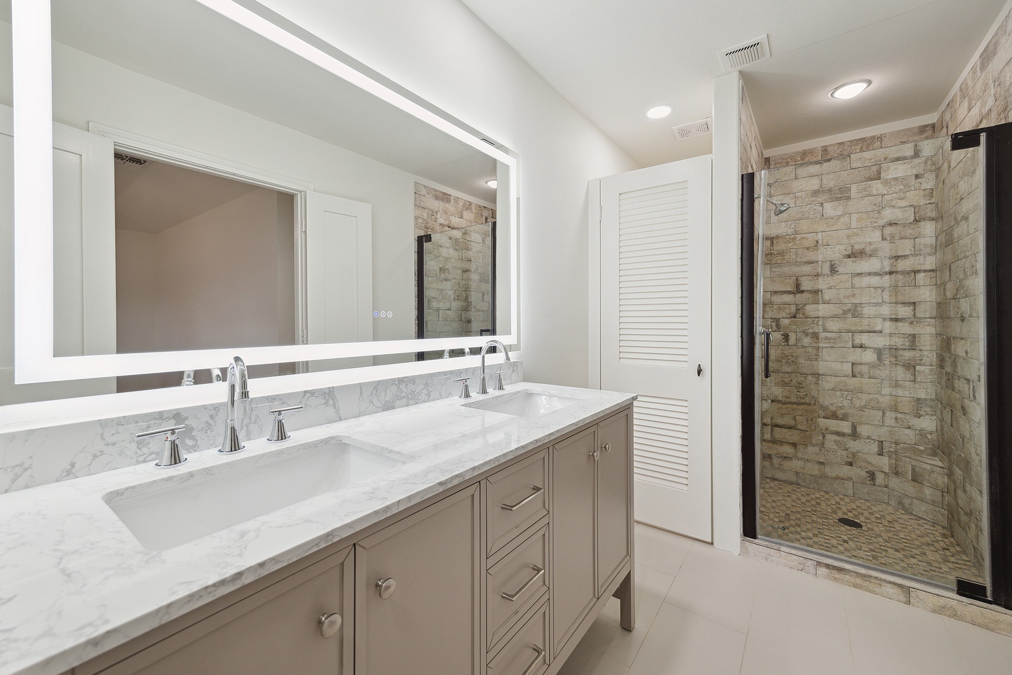9719 Springmont Drive Houston, TX 77080 - Photo 22 of 32 Master bathroom is a GEM!! High-end LED mirror reflects all the luxury!! From an elegant vanity console, DOUBLE SINKS, gleaming plumbing fixtures, and gorgeous tiled shower, and a discreet toilet area … everything serves to create a tranquil spa-like feel!!