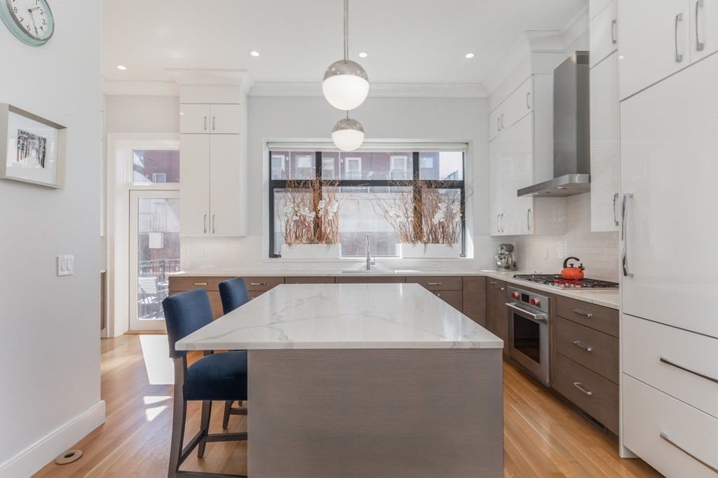 a kitchen with stainless steel appliances granite countertop a sink a stove and a refrigerator