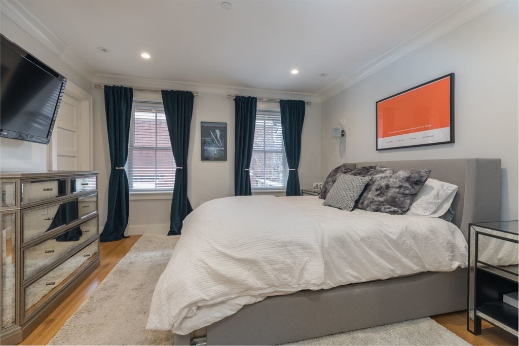 44 Upton Street, Unit 1 Boston, MA 02118 - Photo 15 of 35 a bedroom with a large bed and a flat screen tv