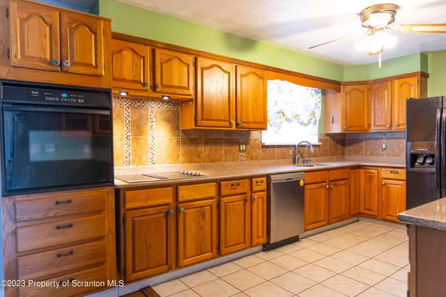 a kitchen with granite countertop cabinets stainless steel appliances a sink and a large window