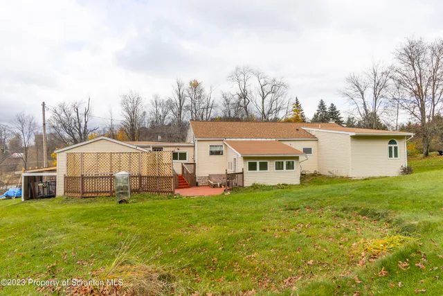 a view of a big house with a big yard and large trees