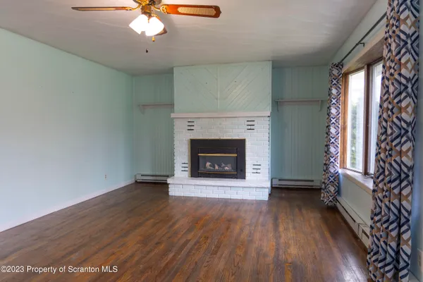wooden floor fireplace and windows in an empty room