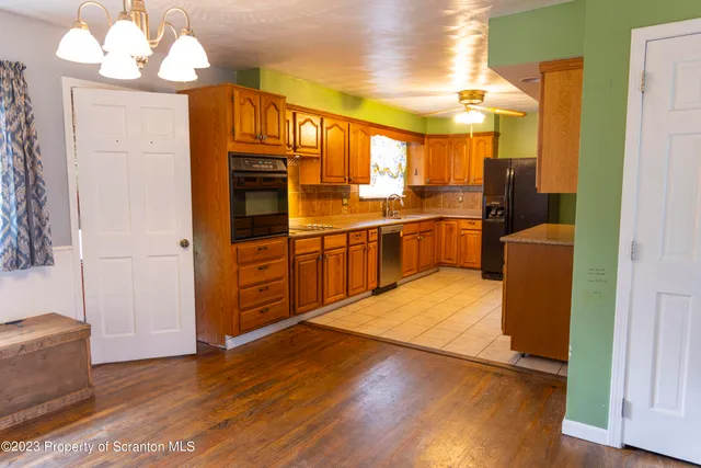 a kitchen with stainless steel appliances granite countertop a refrigerator a stove and a wooden floors