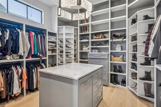 a view of walk in closet with clothes and shoes