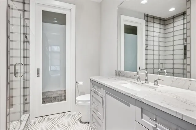 a bathroom with a granite countertop sink toilet and shower
