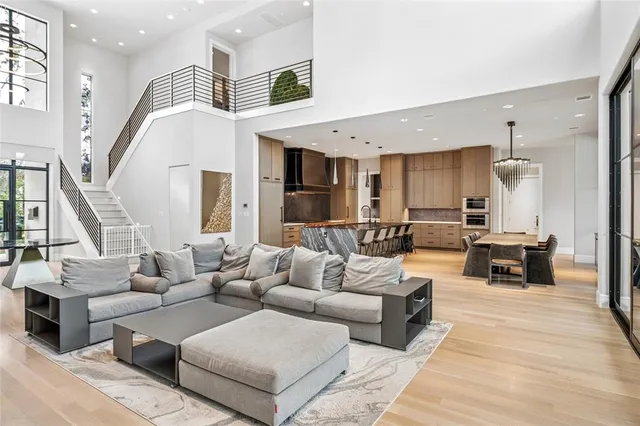 a living room with furniture kitchen view and a large window