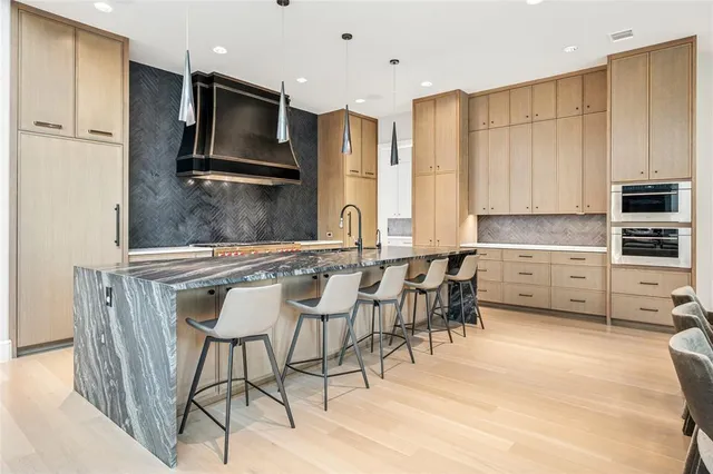 a kitchen with stainless steel appliances granite countertop a stove a sink a microwave a refrigerator and cabinets