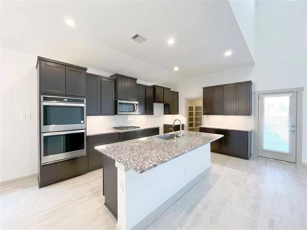 28310 Hazel Trail Katy, TX 77494 - Photo 7 of 26 a large kitchen with a large counter top stainless steel appliances and cabinets