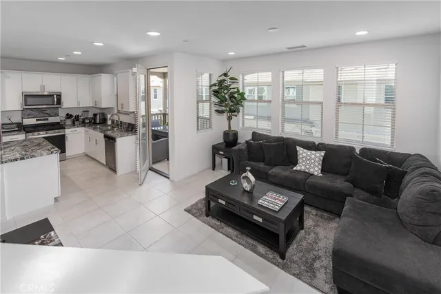 a living room with furniture kitchen and a large window